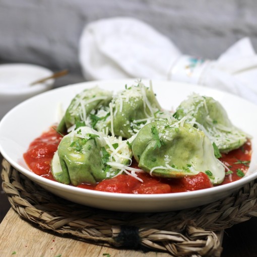 Handgemachte Spinat-Ravioli mit Tomatenragout und frisch geriebenem Parmesan 