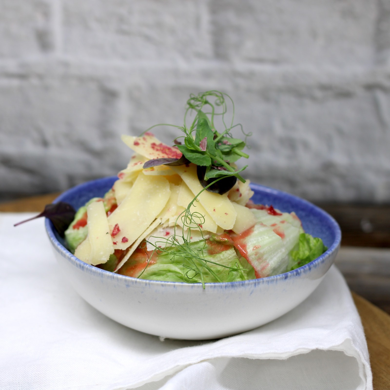 Eisbergsalat mit knusprigen Croutons, Parmesanhobel und Caesar Dressing