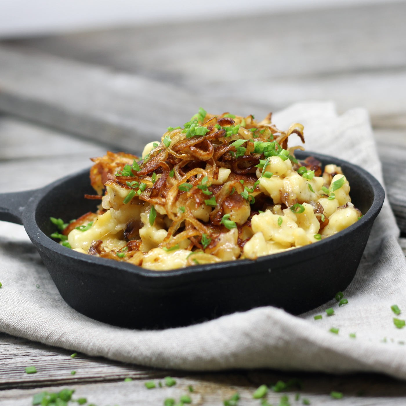 Kasnocken mit Röstzwiebel, frischem Schnittlauch und Eisbergsalat