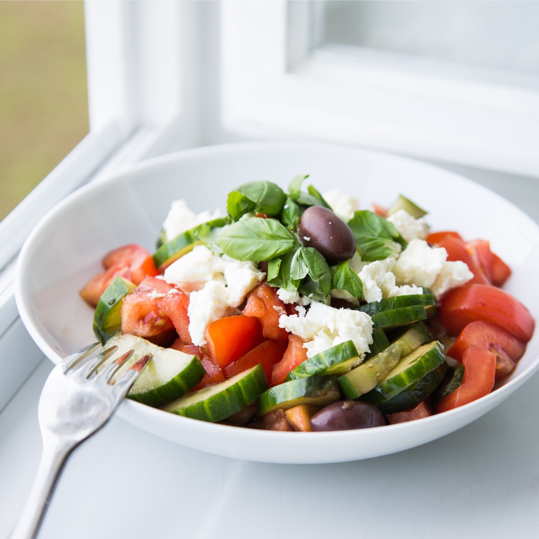 Griechischer Salat mit frischem Basilikum und Oliven